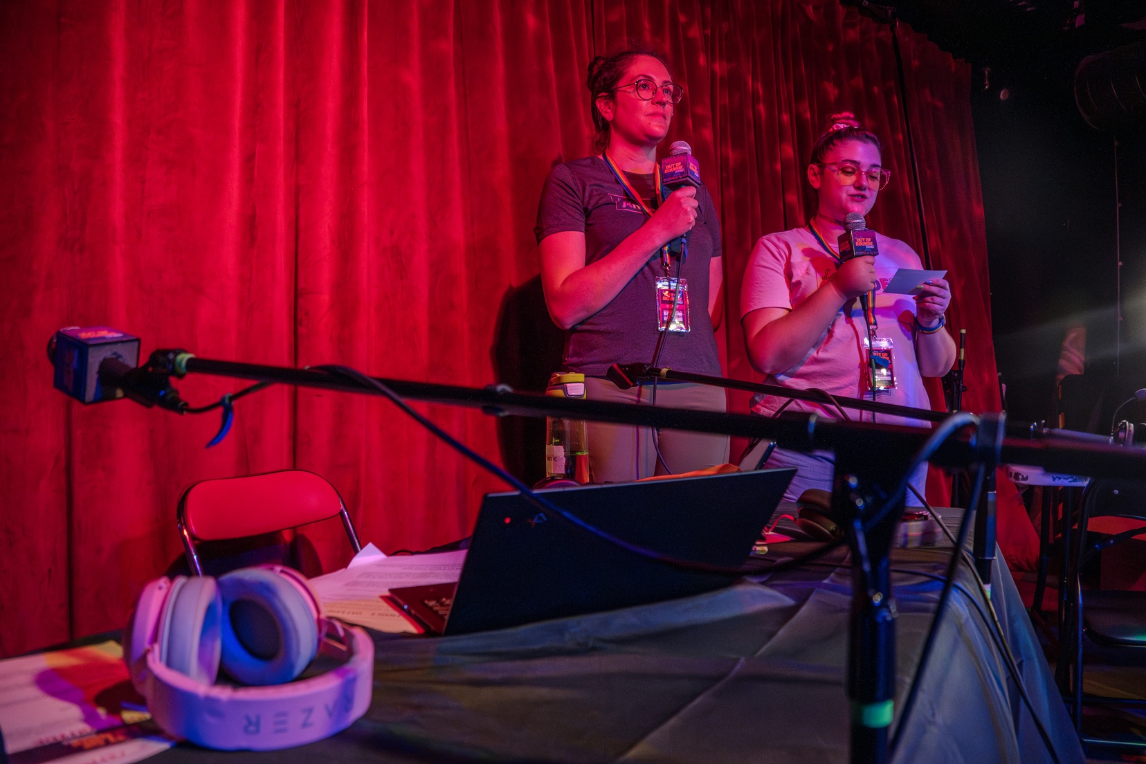 Two women are standing holding microphones.